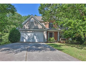 Charming two-story home featuring a two-car garage and a manicured front lawn with lush greenery at 1387 Sw Haynes Meadow Trl, Grayson, GA 30017