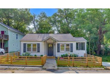 Charming home featuring a manicured lawn, inviting entryway, and neutral colored shutters at 845 Oak Nw St, Atlanta, GA 30318