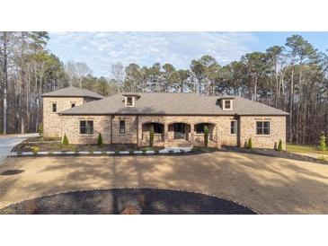 Beautiful brick home featuring manicured lawn, arched entryway, and thoughtfully designed landscaping at 1380 Sw Elva Sw Dr, Atlanta, GA 30331