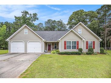 Charming single-story home with a two-car garage, well-maintained lawn, and lovely landscaping at 169 Winding Valley Dr, Rockmart, GA 30153
