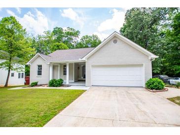 Charming single-story home featuring a painted brick facade, attached two-car garage, and manicured front lawn at 9691 Squirrel Wood Run, Douglasville, GA 30135