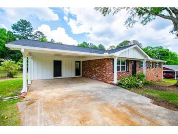 Charming single story brick home with a covered carport and manicured landscaping at 6213 Cherry Ln, Douglasville, GA 30134