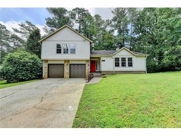 Charming two-story home with a well-manicured lawn, two-car garage, and bright red front door at 4398 Stonebridge Ct, Duluth, GA 30096