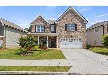 Charming two-story brick home with a well-manicured lawn and attached two-car garage at 7207 Gladstone Cir, Stonecrest, GA 30038
