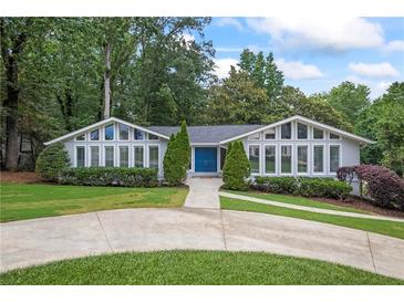 Charming home with a well-manicured lawn, lovely landscaping, and a welcoming blue double-door entry at 3009 Gant Quarters Dr, Marietta, GA 30068
