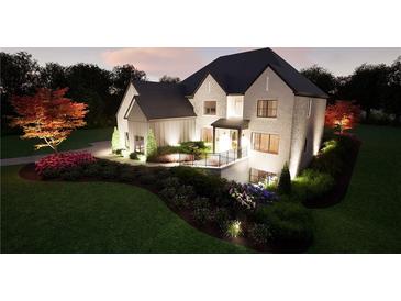 Stunning brick home showcasing manicured landscaping with vibrant flowerbeds and warm exterior lighting at 3680 Tanglewood Se Dr, Atlanta, GA 30339