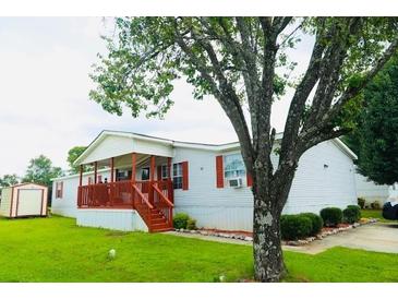 Charming manufactured home boasts a welcoming red porch and well-maintained landscaping at 263 Gulfport Ct, Hampton, GA 30228