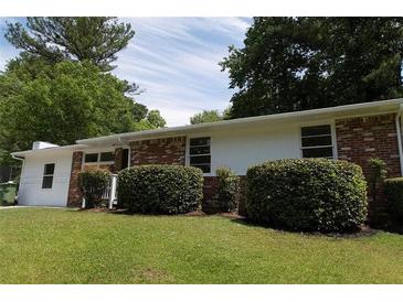 Ranch-style home with a brick exterior, lush landscaping, and a well-maintained lawn at 70 Ruzelle Se Dr, Atlanta, GA 30354