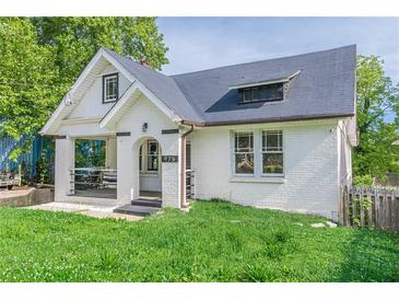 Charming one-and-a-half-story home with white painted brick, black trim and a covered porch with arched entryway at 975 Dill Sw Ave, Atlanta, GA 30310