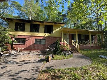 Two-story home showcasing fire damage, with debris scattered across the front yard and charred windows visible at 447 Martindale Ct, Stone Mountain, GA 30088