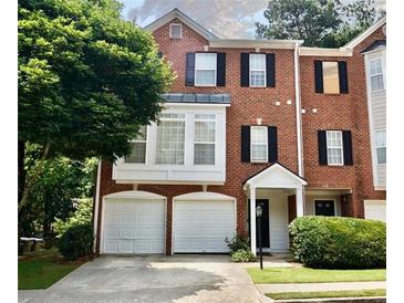 Charming brick townhome with a two-car garage and well-manicured landscaping at 5996 Eagle Tiff Ln, Sugar Hill, GA 30518