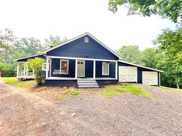 Charming home features a covered porch with a swing and a detached garage with crossbuck doors at 776 Green Dr, Canton, GA 30114