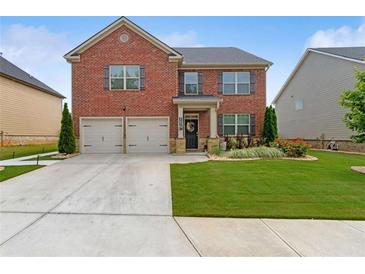 Charming two-story brick home with a well-manicured lawn and two-car garage in a desirable neighborhood at 3303 Hawthorn Farm Blvd, Loganville, GA 30052