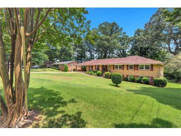 Charming single story brick home with a large lawn and mature landscaping at 4177 Hapsburg Ct, Decatur, GA 30034