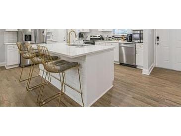 Bright kitchen featuring a center island, white cabinetry and stainless steel appliances at 2089 Quilt Ct, Lithonia, GA 30058