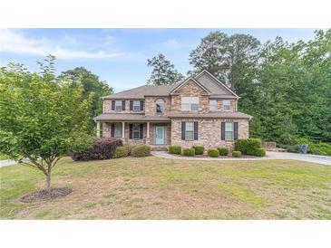 Charming two-story brick home with a well-manicured lawn, and a welcoming light blue front door at 1022 Nestling Dr, Lawrenceville, GA 30045