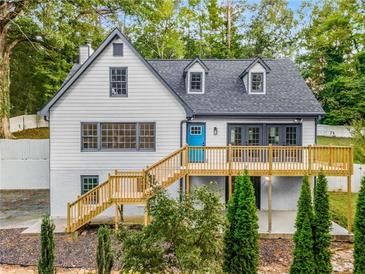 Charming two-story home with a bright blue door and a spacious wooden deck, nestled in a lush green landscape at 2552 Hunton Ne Ct, Marietta, GA 30068