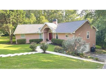 Charming single-Gathering home featuring a landscaped lawn, inviting walkway, and an attached two-car garage at 4221 Riverlake Way, Snellville, GA 30039