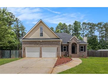 Charming two-story home boasts a brick and siding exterior, attached two-car garage, and a well-manicured front lawn at 232 Christian Cir, Carrollton, GA 30116