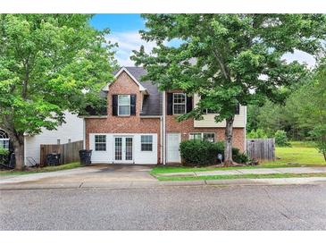 Charming two-story home with a brick facade and a lush green yard at 433 Pearl St, Locust Grove, GA 30248