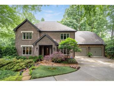 Brick home featuring a well-manicured lawn and a two-car garage at 5049 Lake Ter, Marietta, GA 30068