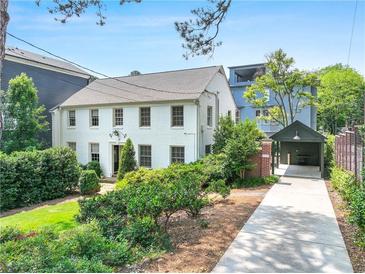 Charming two-story white home with lush landscaping and a convenient covered parking area at 67 Delmont Ne Dr, Atlanta, GA 30305