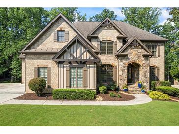 Charming home with brick and stone facade, lush lawn and landscaping at 2517 Stone Manor Dr, Buford, GA 30519