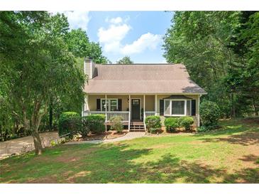 Charming single-Gathering home with a welcoming front porch and lush landscaping, creating a serene curb appeal at 124 Hunters Mill Rd, Woodstock, GA 30188