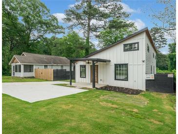 Charming home featuring a modern design, a well-manicured lawn, and a spacious concrete driveway at 2822 Waters Sw Rd, Atlanta, GA 30354