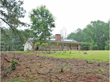 Ranch-style home on a grassy lot with a brick chimney and covered porch at 3129 Etchison Rd, Loganville, GA 30052