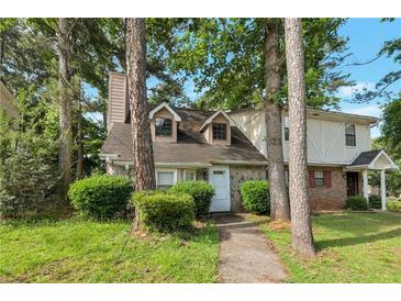 Charming townhouse with stone accents and mature trees surrounding the landscaped front yard at 134 Timber Creek Sw Ln, Marietta, GA 30060