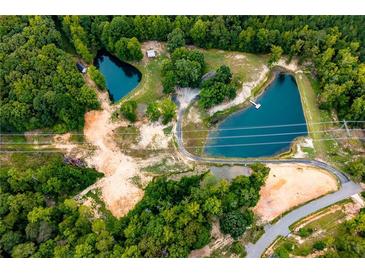 Expansive aerial view of property featuring mature trees, two ponds and unpaved access roads at 300 Old Boy Scout Rd, Whitesburg, GA 30185