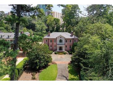 Stately red brick home with manicured lawn, mature trees, and circular driveway at 2883 Andrews Nw Dr, Atlanta, GA 30305