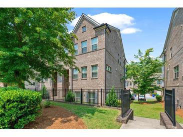 Well maintained townhouse with manicured landscaping and black metal fence surrounding the property at 1463 Edgebrook Ne Ct # 14, Atlanta, GA 30329