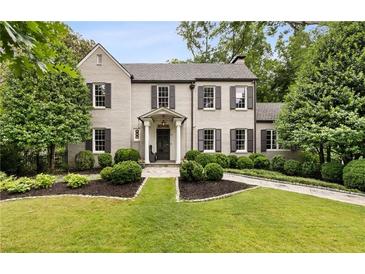 Charming two-story home with a manicured lawn, gray painted brick, and black shutters at 241 Nacoochee Nw Dr, Atlanta, GA 30305