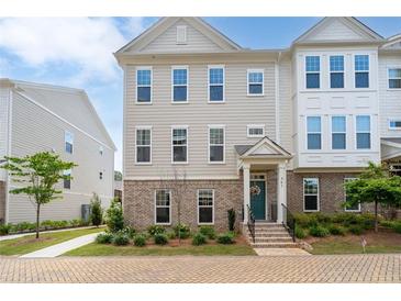 Charming townhouse featuring a brick facade, inviting entrance, and meticulously manicured landscaping at 361 Watson Ave, Woodstock, GA 30189