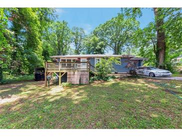 Charming single-story home featuring a wooden deck and lush greenery surrounding the property at 3220 Memorial Dr, Decatur, GA 30032