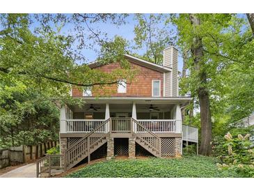 Charming two-story home featuring a spacious covered porch, shingle siding, and lush greenery all around at 443 Lakeshore Ne Dr, Atlanta, GA 30307