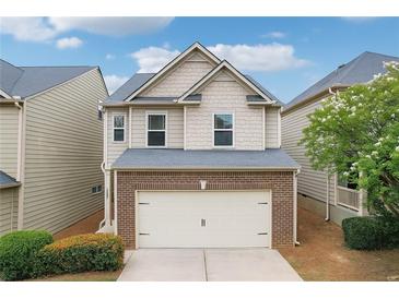 Charming home featuring a two-car garage, brick accents, and beautifully maintained landscaping at 503 Mill Ridge Rd, Woodstock, GA 30188