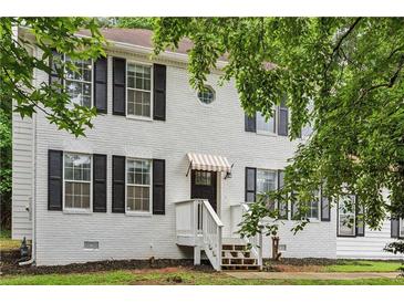 Charming two-story home with white painted brick, black shutters and awning over the front door at 2201 Logan Dr, Jonesboro, GA 30236