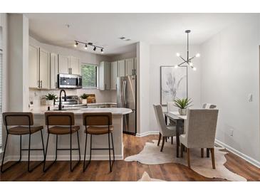 Bright kitchen and dining area with stainless steel appliances, bar seating and modern lighting at 821 Ralph Mcgill Ne Blvd # 2219, Atlanta, GA 30306