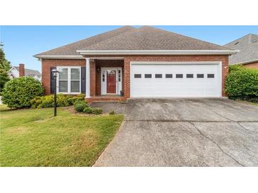 Charming one-story brick home featuring an attached two-car garage and manicured front lawn at 2260 Burlington Ln, Snellville, GA 30078