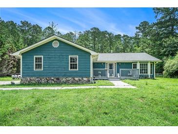 Charming one-story home with inviting front porch and a well-manicured lawn in a wooded area at 2969 White Ne Rd, Conyers, GA 30012