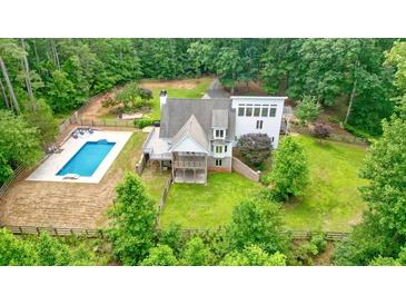 Expansive estate featuring a large pool and secluded backyard, surrounded by lush greenery and mature trees at 326 Seldom Seen Trl, Canton, GA 30115