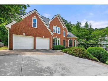 Beautiful two-story brick home featuring a two-car garage and manicured landscaping at 542 Fairway Dr, Woodstock, GA 30189