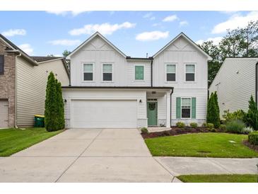 Charming two-story home featuring white siding, green shutters and door, plus a well-manicured lawn at 149 Archie Way, Woodstock, GA 30188