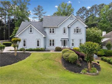 Charming two-story home with a well-manicured lawn and a combination of green trees and colorful landscaping at 5711 Brynwood Nw Cir, Acworth, GA 30101
