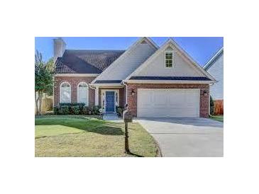 Charming one story brick home with a well manicured lawn, two-car garage, and inviting blue front door at 2163 Berryhill Se Cir, Smyrna, GA 30082