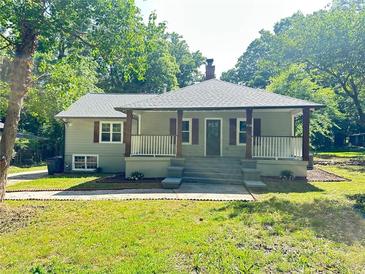 Charming home with covered porch, grey siding, green lawn and mature trees in a quiet neighborhood setting at 6538 N Sweetwater Rd, Lithia Springs, GA 30122