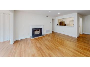 Bright living room featuring a classic fireplace, hardwood floors and an open view of the modern kitchen at 1601 Augusta Se Dr, Marietta, GA 30067